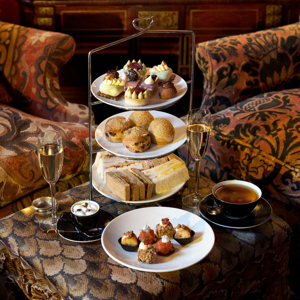 Three-tier stand of sandwiches, scones and pâtisserie served with tea and champagne in the luxurious lounge at Prestonfield House, capturing the indulgent experience of one of the best afternoon teas in Edinburgh