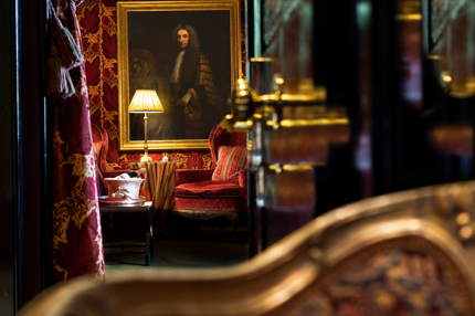 Painting and antique lamp surrounded by maroon velvet during Prestonfield House luxury DBB deal stay in Edinburgh 
